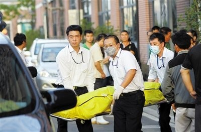 昨日,上海市宝山区殡仪馆的工作人员在搬运遇难者遗体.