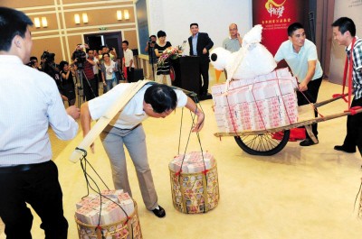 陈光标让员工用小车推着和扁担挑着3270万元巨款现金亮相现场,并承诺