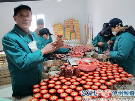 许开明(左一)在介绍豆腐乳制作流程