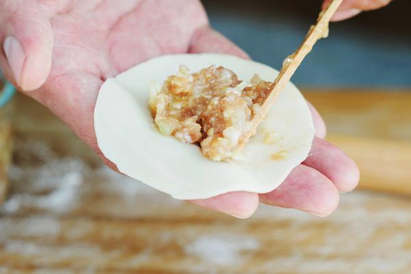 11,挖适量调好的饺子馅放在饺子皮中间位置.