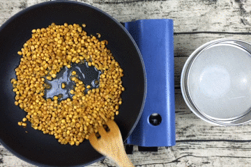 冷油冷锅,倒入黄豆,加少量盐,不断翻炒均匀.