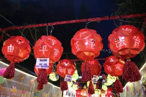 社区居民将红色卡纸镂空雕刻二十四字,再折成灯笼形状,让人们在欣赏