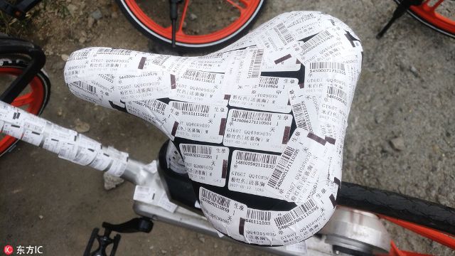 广州共享单车停路边 被贴满小广告(图)