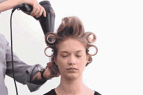 2,将头发上好卷后,再用吹风机轻吹每一个卷发筒,加快头发的定型,也能