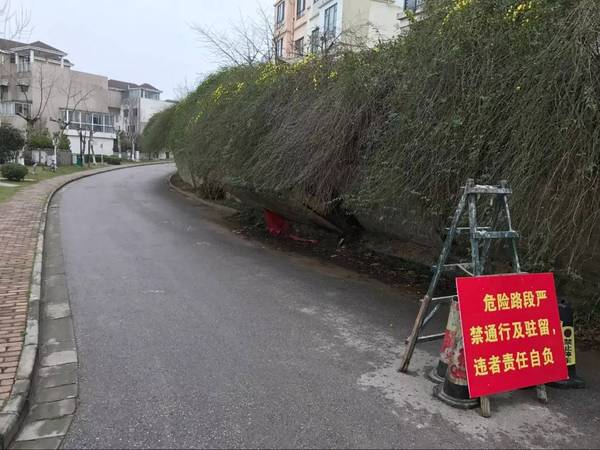 挡土墙一侧的道路前架起了警示标语,禁止车辆通行及驻留.