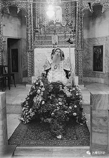 一名主教逝世后将他放在椅子上坐着,好像打盹一样,周围放满了鲜花.