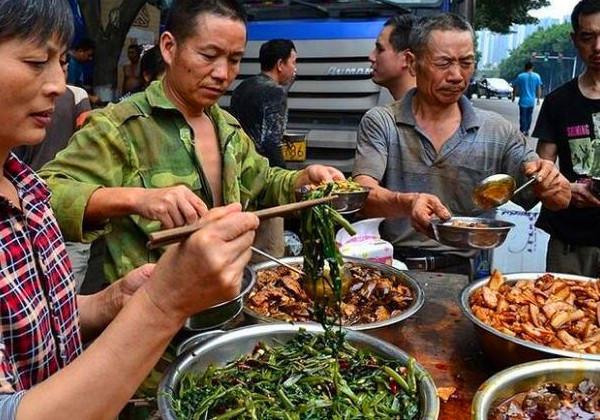 图为农民工正在打中午饭菜,这是务工的单位给他们加