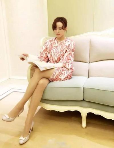 胡静身穿红色刺绣连衣裙,慵懒的坐在沙发上,迷人美腿很抢镜.
