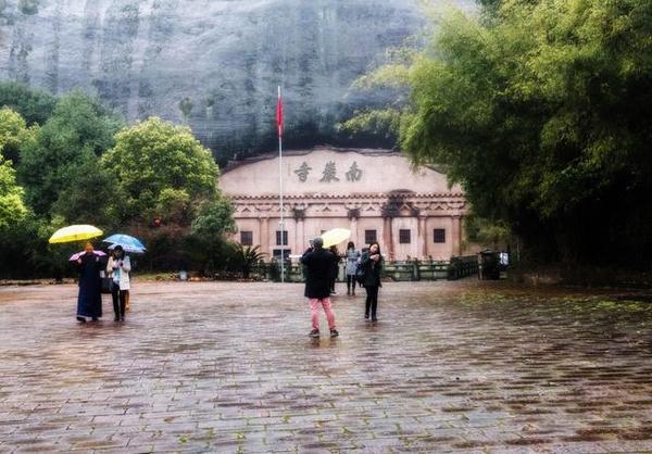 摄影/钟晶晶老师(我与南岩古寺住持的合影) 今天,在年轻的圆坤师傅主持下,南岩古寺又一次焕发了佛光生机,日渐香火鼎盛并成为远近闻名蜚声海外的著名寺院和传播佛法的圣地 关于南岩古寺(石窟) 南岩古寺,又名南岩佛窟或南岩佛洞,实际上是一座难得的佛教石窟。位于江西上饶市弋阳县城郊南岩山下,在江西弋阳国家重点风景名胜区龟峰二景区(南岩景区)内。是一座依托于天然岩石形成的大洞穴而建的古寺庙。洞内现存石龛40余座,摩崖石刻10余处,依岩环列成半圆形,龛内雕塑有释迦牟尼、文殊、普贤、观音大士、十八罗汉等佛雕以及宝塔等
