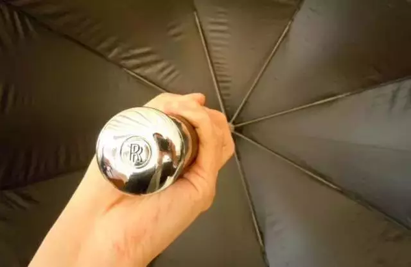 伞就可以自动弹出 而伞托上镌刻着劳斯莱斯的双r标志 加上这把黑色