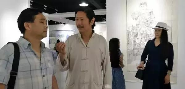 湖北省国画院副院长胡学武(右一)向董继宁介绍展览现场,湖北省国画院