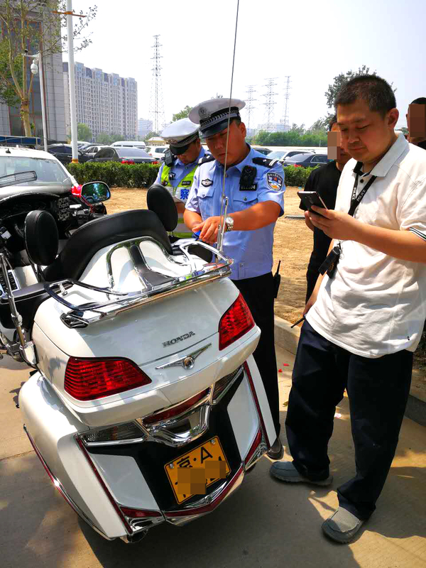 民警在对一辆悬挂假牌照的本田金翼摩托车进行检查