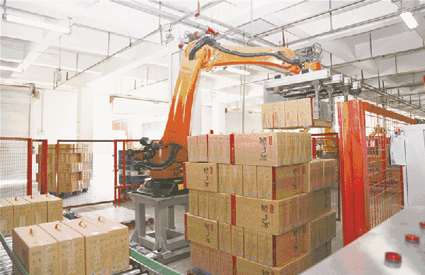 视频中显示一台黄色的机器人正在忙着装箱,机器人熟练地将流水线上