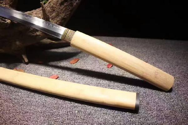 楠竹T10烧刃弯款唐刀--居合刑天 〖特点〗:此刃型为大V刃面平整锋利劈砍阻力小,整体刀型由刀簇向刀尖径向逐渐加宽,轴向渐薄锻打,采用覆土烧刃工艺加温至1200度,在冷水中淬火,温度骤降从而产生烧刃线,刃口具备超高硬度,刀背韧性仍保留,从而达到刚柔并济优质刀剑,正是一刀两世界,相生相克! 黄金比例重心护手前10厘米,二级黑檀木色泽柔亮手感细腻,一款收藏级刀剑! 〖总长〗:103厘米 〖刃长〗:72 厘米 〖柄长〗:27厘米 〖刃宽〗:3.