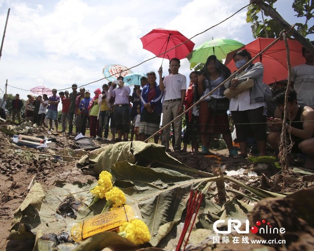 当地时间2013年10月17日,老挝巴色士兵正勘查失事飞机坠毁的残骸