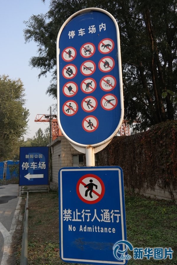 北京,朝阳公园西门1号门停车场门口的提示牌"填满"了13个禁止标识