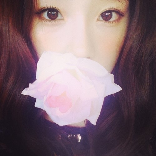 亚洲经济》报道,韩国人气女团少女时代的成员泰妍一张嘴衔玫瑰的自拍