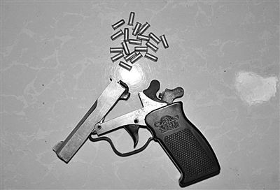 警方从抢劫嫌疑人处起获的赃款和发令枪,子弹.警方供图