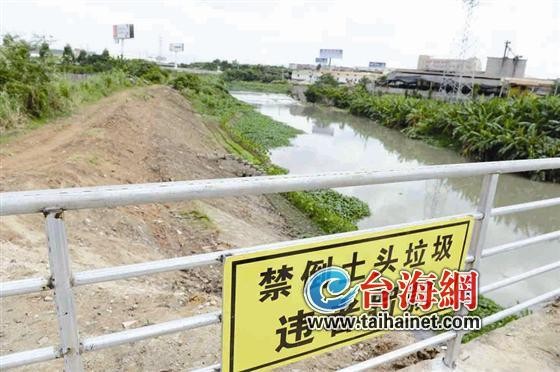 隔离栏挂上了写有"禁倒土头垃圾违者罚款"的警示