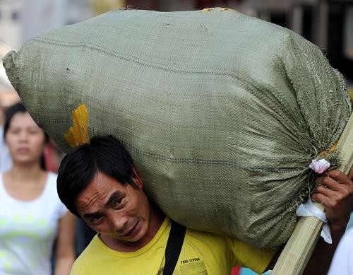 9月18日,一名旅客扛着行李走过郑州市火车站站前广场.