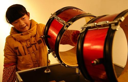1月2日,一名小学生在聊城市运河文化博物馆体验会发声的无皮鼓.