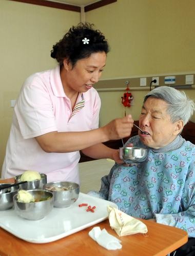 在河北省三河市燕达国家建康城养护中心,护理员正在为一名老人喂食