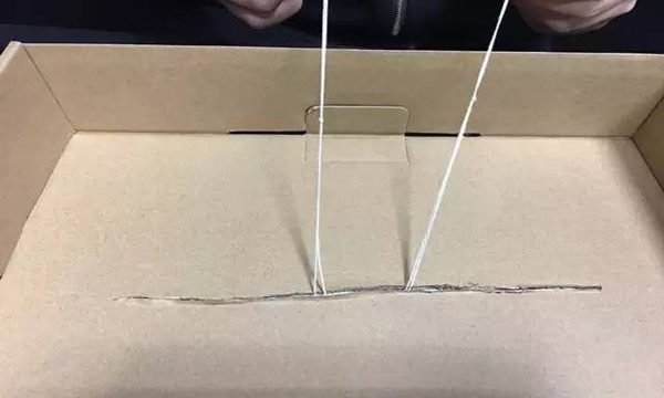 把两根绳子穿过盒子上的缝隙在下方拉