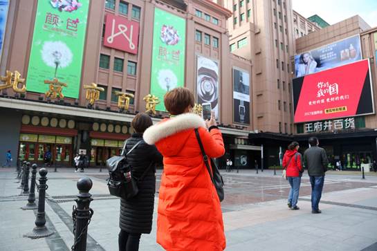 北京王府井大街,行人在"你好 我的国"大屏幕前驻足