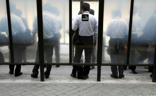 图为一群日本男人在吸烟区抽烟,在日本大部分公共场所都是禁止吸烟的