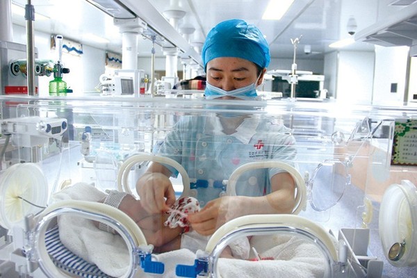新生儿科护士正在给早产儿换尿布.